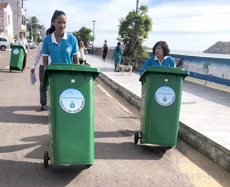 Hoa hậu Hoàn vũ 2017 H’Hen Niê và các đại biểu Hội liên hiệp phụ nữ tỉnh Bình Định trao tặng thùng rác cho xã Nhơn Hải, thành phố Quy Nhơn (Bình Định) nhằm chia sẻ thông điệp về lối sống xanh, bảo vệ môi trường. (Ảnh: Lê Ngọc Phước/TTXVN).