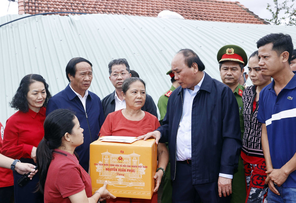 Chủ tịch nước Nguyễn Xuân Phúc và đoàn công tác tới thăm hỏi, động viên và tặng quà gia đình bà Đỗ Thị Thanh Hoa, ở thôn Thạch Nham Đông, xã Hòa Nhơn, huyện Hòa Vang, thành phố Đà Nẵng. (Ảnh: Thống Nhất/TTXVN)
