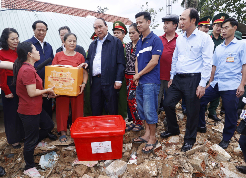 Chủ tịch nước Nguyễn Xuân Phúc và đoàn công tác tới thăm hỏi, động viên và tặng quà gia đình bà Đỗ Thị Thanh Hoa, ở thôn Thạch Nham Đông, xã Hòa Nhơn, huyện Hòa Vang, thành phố Đà Nẵng. (Ảnh: Thống Nhất/TTXVN)