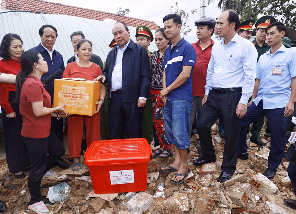 Chủ tịch nước Nguyễn Xuân Phúc và đoàn công tác tới thăm hỏi, động viên và tặng quà gia đình bà Đỗ Thị Thanh Hoa, ở thôn Thạch Nham Đông, xã Hòa Nhơn, huyện Hòa Vang, thành phố Đà Nẵng. (Ảnh: Thống Nhất/TTXVN)