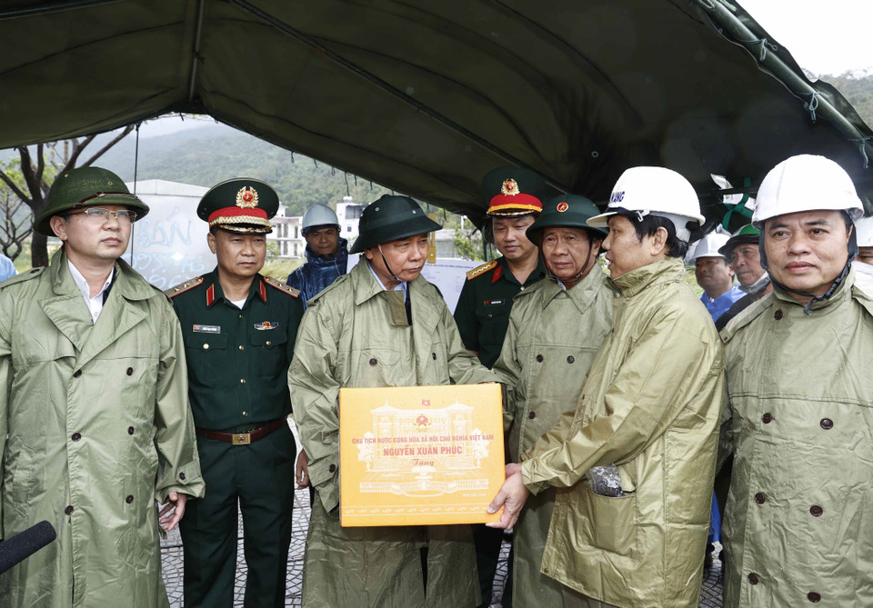 Chủ tịch nước Nguyễn Xuân Phúc tặng quà cho các lực lượng đang triển khai công tác khắc phục thiệt hại các công trình hạ tầng tại điểm sạt cuối đường Lê Văn Lương, Hoàng Sa, phường Thọ Quang, quận Sơn Trà. (Ảnh: Thống Nhất/TTXVN)