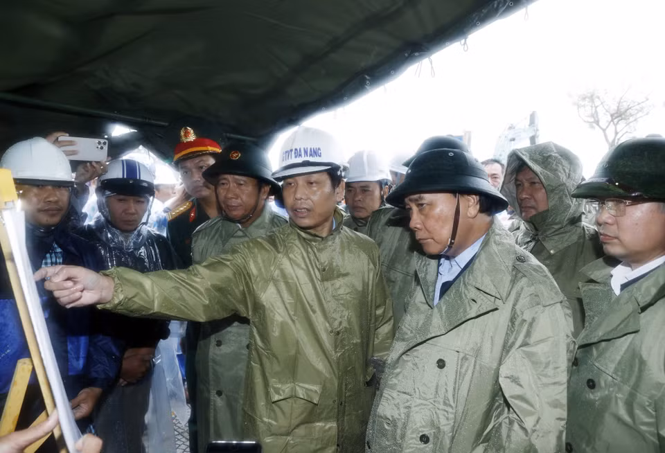 Chủ tịch nước Nguyễn Xuân Phúc và đoàn kiểm tra thực địa công tác khắc phục thiệt hại các công trình hạ tầng tại điểm sạt cuối đường Lê Văn Lương, Hoàng Sa, phường Thọ Quang, quận Sơn Trà. (Ảnh: Thống Nhất/TTXVN)