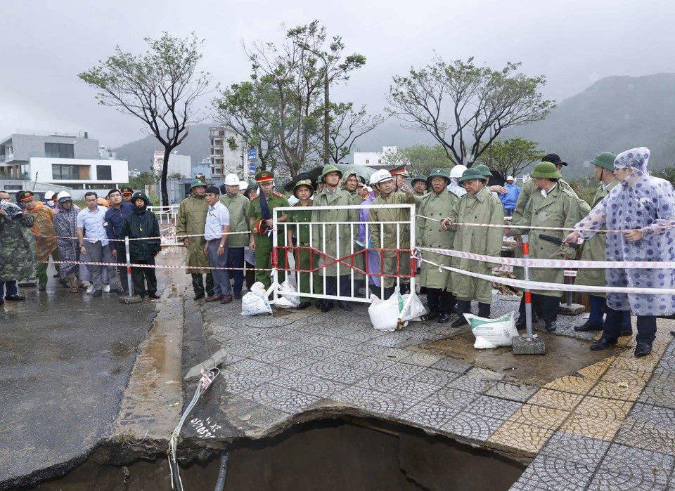 Hình ảnh Chủ tịch nước Nguyễn Xuân Phúc và đoàn kiểm tra thực địa công tác khắc phục thiệt hại các công trình hạ tầng tại điểm sạt cuối đường Lê Văn Lương, Hoàng Sa, phường Thọ Quang, quận Sơn Trà. (Ảnh: Thống Nhất/TTXVN)