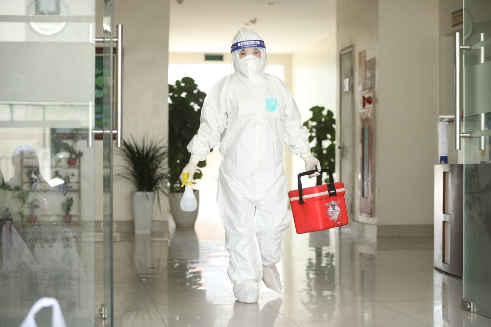 Nhân viên Trung tâm y tế quận Thanh Xuân đến lấy mẫu xét nghiệm cho những người liên quan. (Ảnh: Minh Quyết/TTXVN)