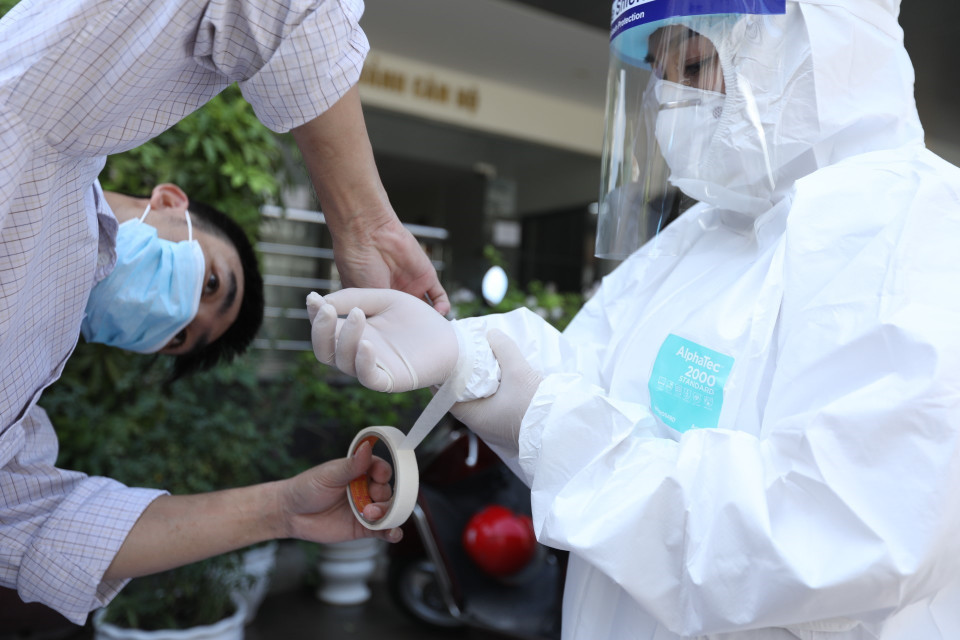 Những người liên quan ca mắc mới được nhân viên Trung tâm y tế quận Thanh Xuân lấy mẫu xét nghiệm.(Ảnh: Minh Quyết/TTXVN)