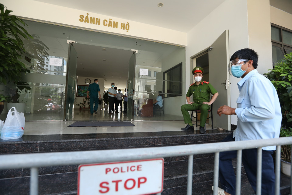 Lực lượng chức năng phong tỏa tạm thời khu chung cư nơi ở của bệnh nhân. (Ảnh: Minh Quyết/TTXVN)