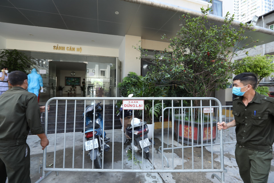 Lực lượng chức năng phong tỏa tạm thời khu chung cư nơi ở của bệnh nhân. (Ảnh: Minh Quyết/TTXVN)