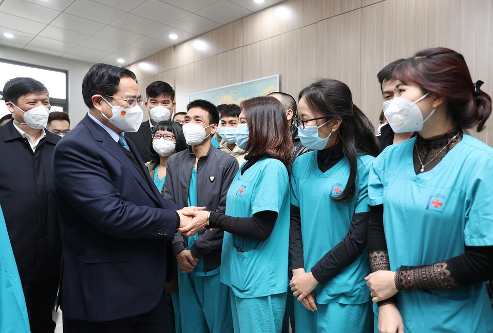Thủ tướng Phạm Minh Chính thăm hỏi , động viên các y, bác sỹ đang điều trị cho các bệnh nhân COVID-19. (Ảnh: Dương Giang/TTXVN)