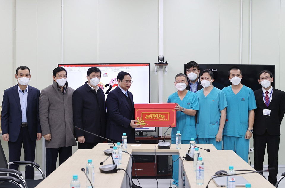 Thủ tướng Phạm Minh Chính tặng quà chúc Tết các bác sỹ, y sỹ Bệnh viện điều trị người bệnh COVID-19. (Ảnh: Dương Giang/TTXVN)