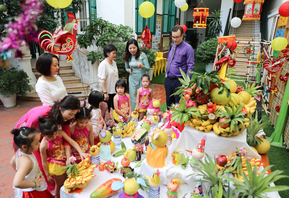Cán bộ Đại sứ quán Pháp khám phá mâm cỗ Trung Thu truyền thống cùng cô và trò Trường Mầm non A (quận Hoàn Kiếm, Hà Nội). (Ảnh: Thanh Tùng/TTXVN)