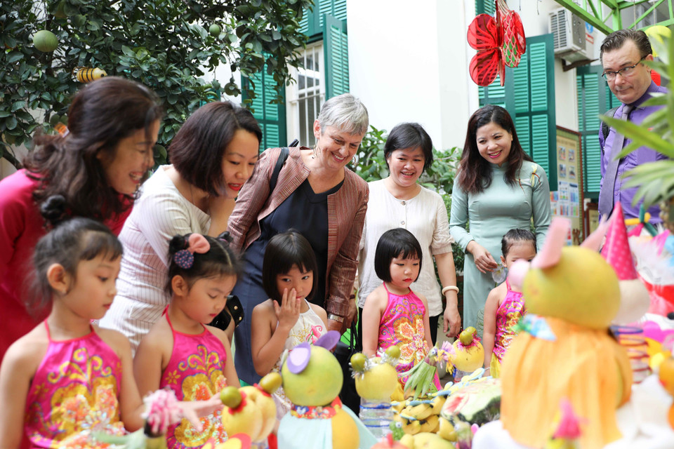 Cán bộ Đại sứ quán Pháp khám phá mâm cỗ Trung Thu truyền thống cùng cô và trò Trường Mầm non A (quận Hoàn Kiếm, Hà Nội). (Ảnh: Thanh Tùng/TTXVN)