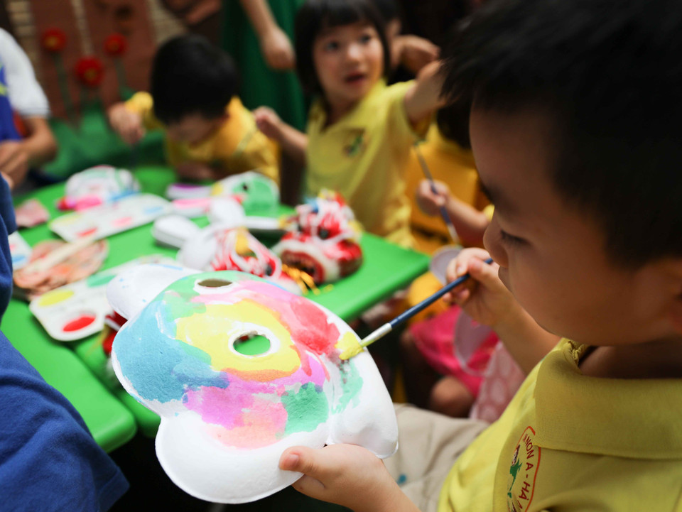 Các bé hào hứng với hoạt động trải nghiệm làm bánh, vẽ mặt nạ, vẽ nón, nặn tò he... trong dịp Tết Trung Thu. (Ảnh: Thanh Tùng/TTXVN)