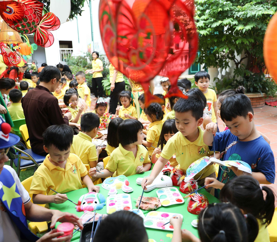 Các bé hào hứng với hoạt động trải nghiệm làm bánh, vẽ mặt nạ, vẽ nón, nặn tò he...trong dịp Tết Trung Thu. (Ảnh: Thanh Tùng/TTXVN)