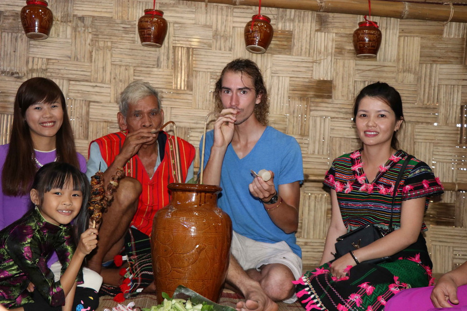 Khách tham quan cùng chủ nhà giao lưu ẩm thực sau lễ cúng. (Ảnh: Ngọc Minh/TTXVN)