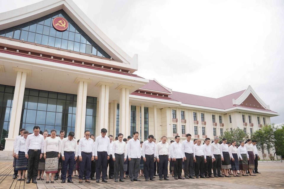 Các cán bộ, nhân viên Văn phòng Trung ương Đảng NDCM Lào dành một phút mặc niệm, bày tỏ niềm tiếc thương sâu sắc trước sự ra đi của đồng chí Tổng Bí thư Nguyễn Phú Trọng. (Ảnh: Đỗ Bá Thành/TTXVN)