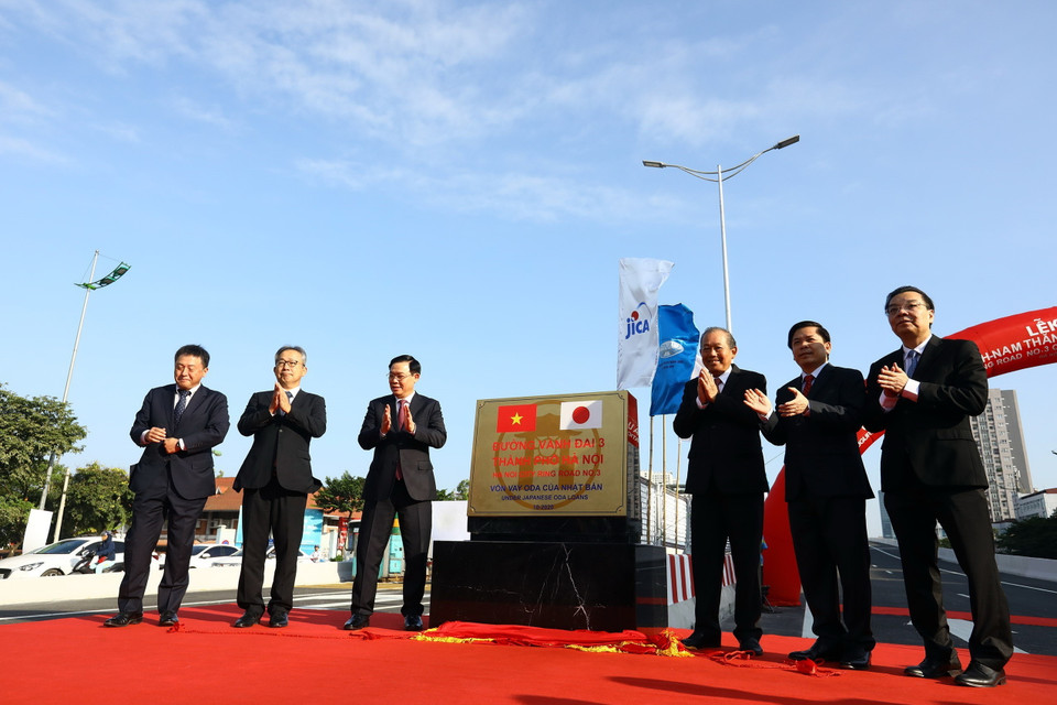 Phó Thủ tướng Thường trực Trương Hòa Bình, Bí thư Thành ủy Hà Nội Vương Đình Huệ, Bộ trưởng Bộ GTVT Nguyễn Văn Thể, Chủ tịch Ủy ban Nhân dân thành phố Hà Nội Chu Ngọc Anh cùng các đại biểu thực hiện nghi thức gắn biển công trình. (Ảnh: Huy Hùng/TTXVN)