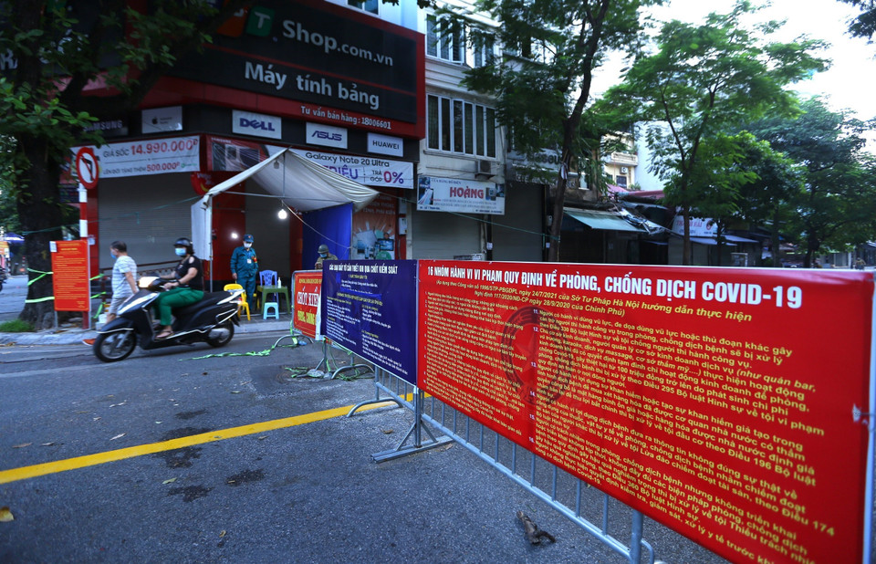 Người dân lưu thông qua chốt phố Thịnh Yên (Hai Bà Trưng) mà không cần xuất trình giấy tờ (ảnh chụp 6h10 ngày 21/9). (Ảnh: Hoàng Hiếu/TTXVN)