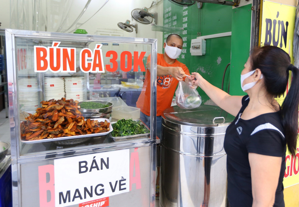 Từ 6h20, một quán bún cá trên phố Mai Hắc Đế đã có khách mua mang về. (Ảnh: Hoàng Hiếu/TTXVN)