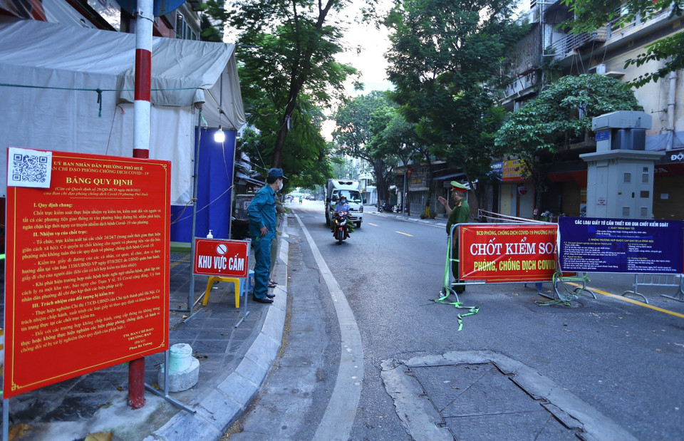 Người dân lưu thông qua chốt phố Thịnh Yên (Hai Bà Trưng) mà không cần xuất trình giấy tờ (ảnh chụp 6h10 ngày 21/9). (Ảnh: Hoàng Hiếu/TTXVN)