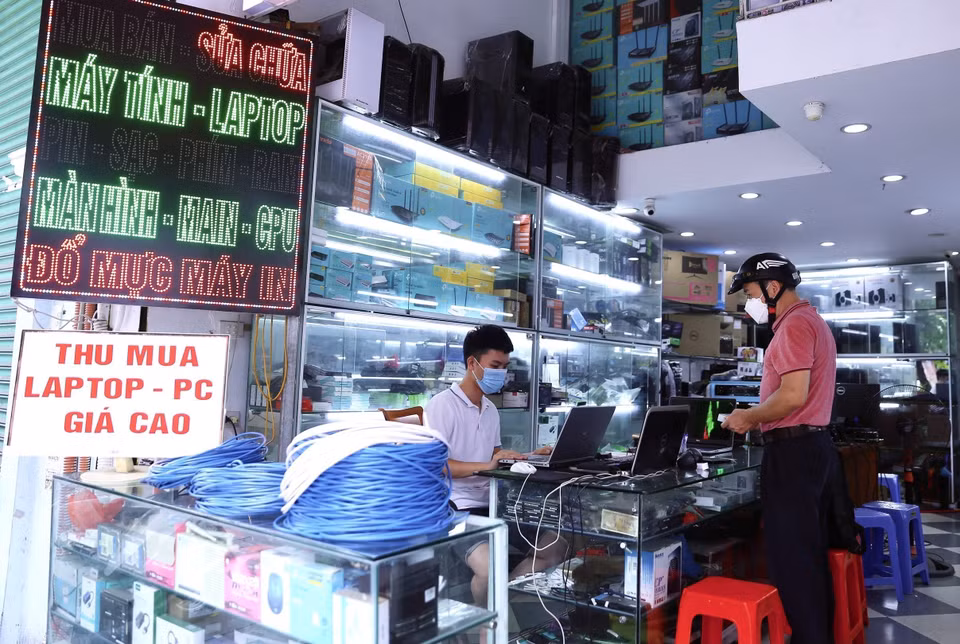 Nhiều người dân đã đến mua bán, sửa chữa máy tính ngay trong ngày các cửa hàng trên phố Lê Thanh Nghị, quận Hai Bà Trưng, mở cửa trở lại. (Ảnh: Hoàng Hiếu/TTXVN)