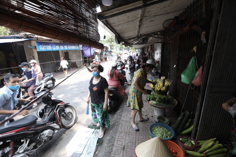  Thành viên tổ COVID cộng đồng phường Phố Huế, quận Hai Bà Trưng, nhắc nhở người dân thực hiện nghiêm các quy định về phòng, chống dịch. (Ảnh: Minh Quyết/TTXVN)