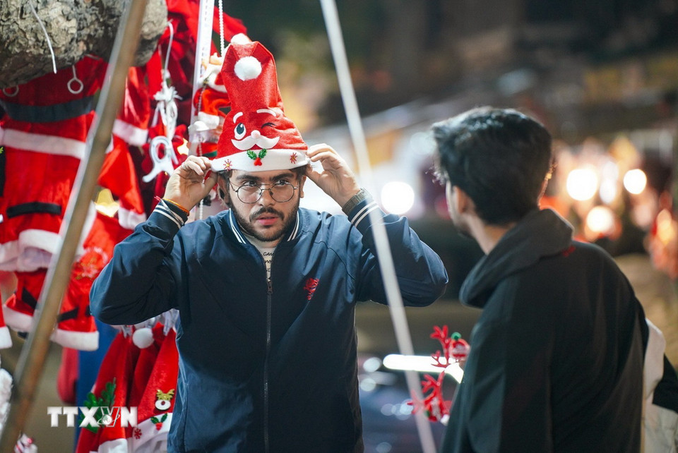 Du khách nước ngoài dạo phố Hàng Mã và chọn cho mình vật phẩm ưng ý trong mùa Giáng sinh 2024. (Ảnh: Khánh Hoà/TTXVN)