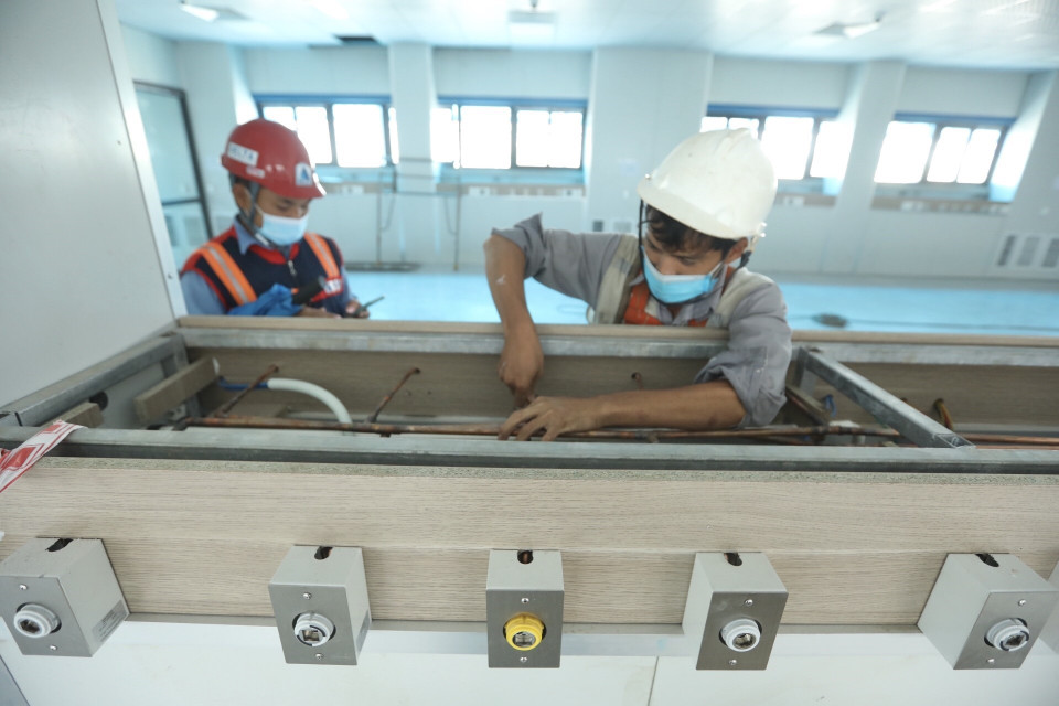 Lắp đặt hệ thống khí y tế tới khu vực giường điều trị cho bệnh nhân tại bệnh viện dã chiến. (Ảnh: Minh Quyết/TTXVN)