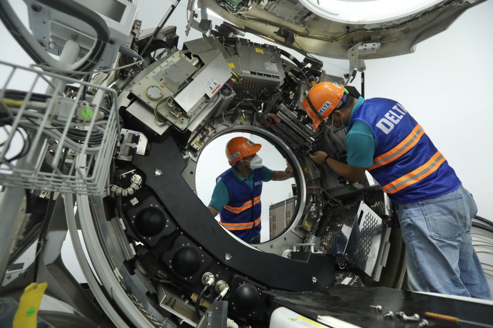 Nhân viên Công ty CP Thiết bị y tế Việt Nhật, đơn vị phối hợp với Bệnh viện Đại học Y Hà Nội hoàn thiện việc lắp đặt máy chụp cắt lớp vi tính tại bệnh viện dã chiến. (Ảnh: Minh Quyết/TTXVN)