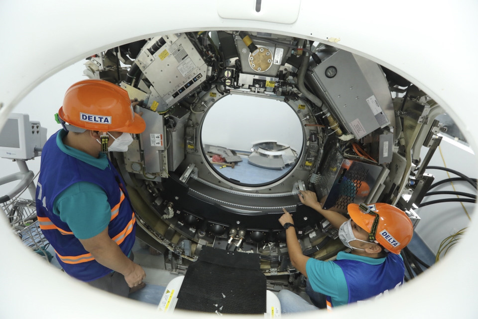 Nhân viên Công ty CP Thiết bị y tế Việt Nhật, đơn vị phối hợp với Bệnh viện Đại học Y Hà Nội hoàn thiện việc lắp đặt máy chụp cắt lớp vi tính tại bệnh viện dã chiến. (Ảnh: Minh Quyết/TTXVN)