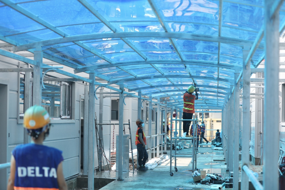 Công nhân hoàn thiện hệ thống chiếu sáng khu vực hành lang nội bộ. (Ảnh: Minh Quyết/TTXVN)