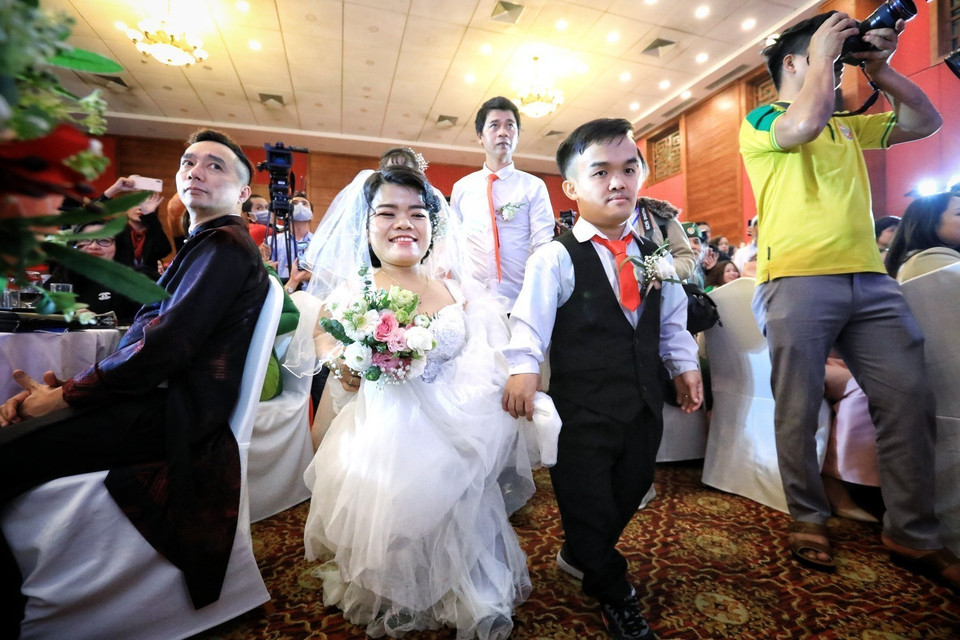 Cặp đôi khuyết tật bước lên sân khấu để chuẩn bị làm lễ cưới tại Lễ cưới tập thể Giấc mơ có thật do Trung tâm Phụ nữ và Phát triển (Hội Liên hiệp phụ nữ Việt Nam) phối hợp với Trung tâm Hỗ trợ Phát triển Phụ nữ Hà Nội tổ chức. (Ảnh: Thành Đạt/TTXVN)