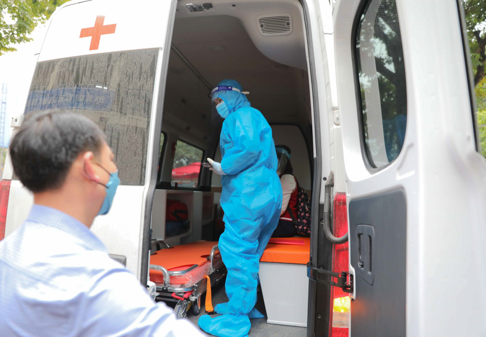 Sau khi học sinh có kết quả dương tính lần 2 sẽ được xe cứu thương chuyển đi điều trị theo quy định. (Ảnh: Thanh Tùng/TTXVN)