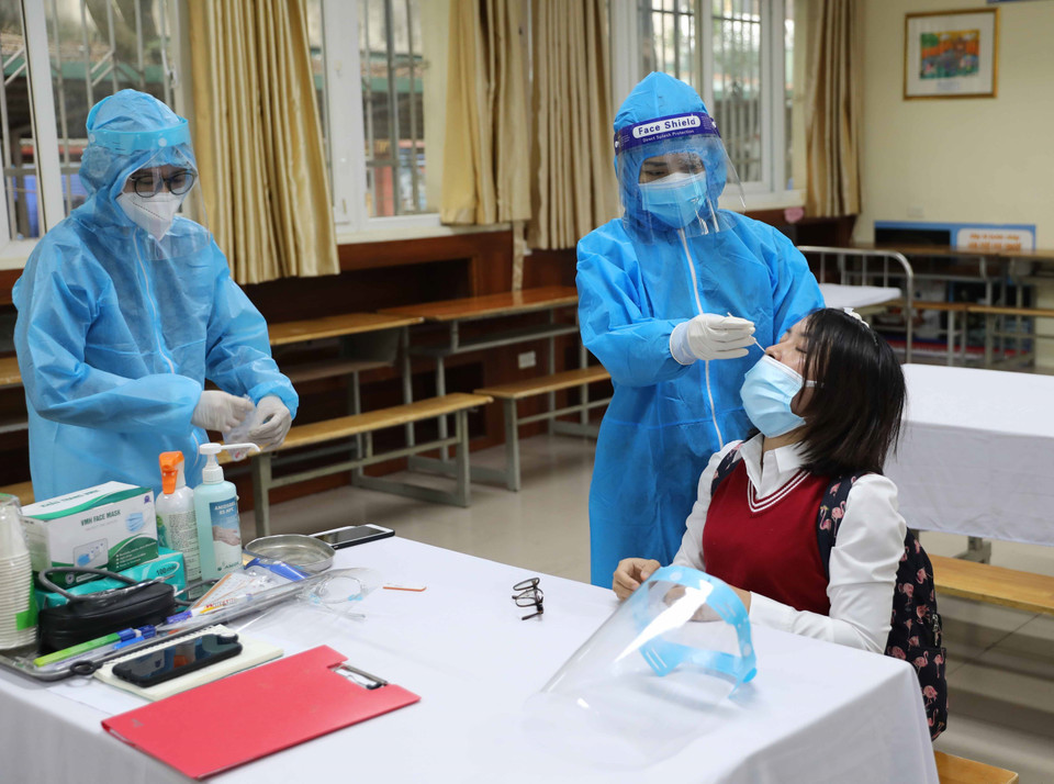 Nhân viên y tế phường lấy mẫu test nhanh lần hai để khẳng định. (Ảnh: Thanh Tùng/TTXVN)