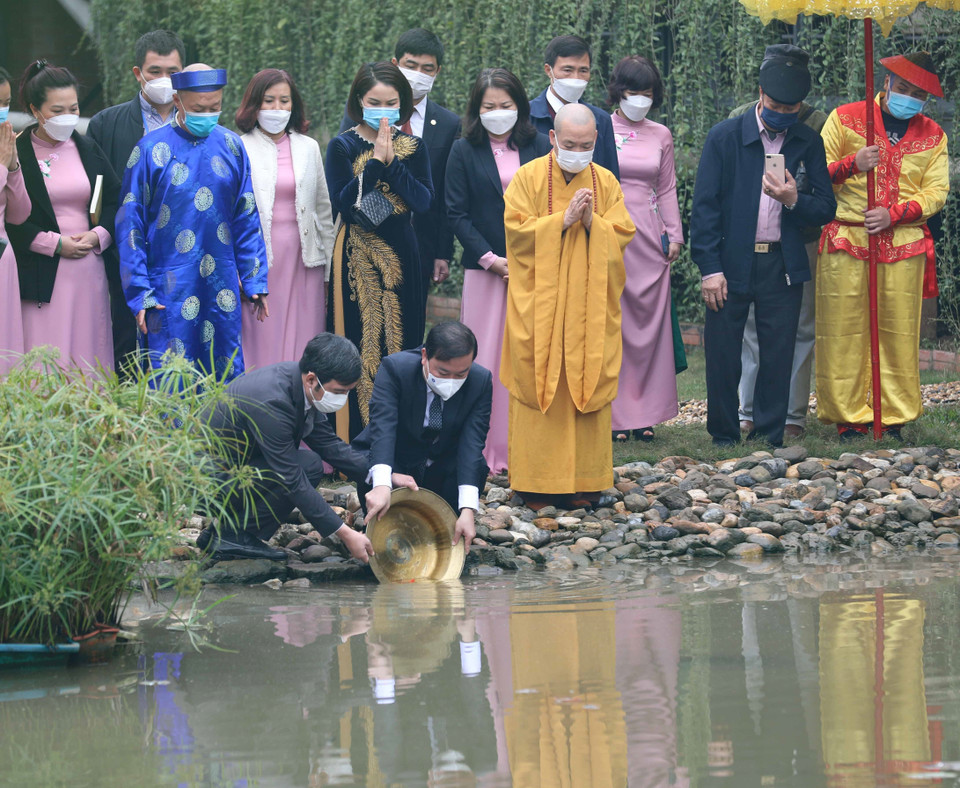 Thả cá chép theo nghi thức truyền thống. (Ảnh: Thanh Tùng/TTXVN)