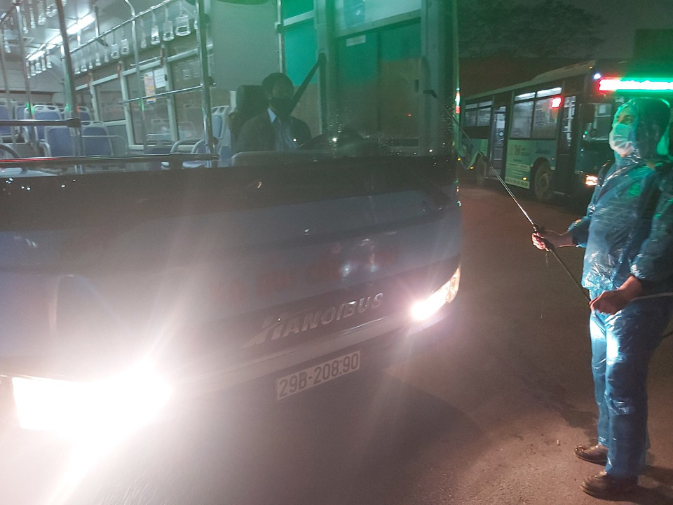 Công việc phun khử khuẩn được tiến hành ngay sau khi xe buýt chạy hết tần suất trong ngày về bến đỗ. (Ảnh: CTV/Vietnam+)