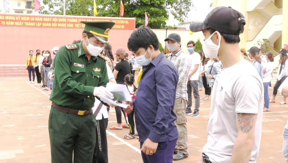 Cán bộ biên phòng trao Giấy chứng nhận hoàn thành cách ly phòng chống dịch bệnh COVID-19 cho các công dân. (Ảnh: Võ Dung/TTXVN)