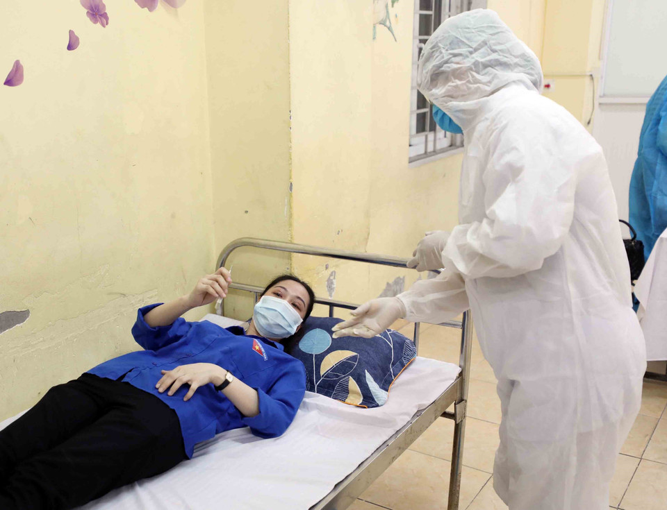 Cán bộ y tế kiểm tra sức khoẻ ban đầu cho thí sinh có biểu hiện ho sốt bất thường để có hướng xử lý tiếp theo. (Ảnh: Thanh Tùng/TTXVN)