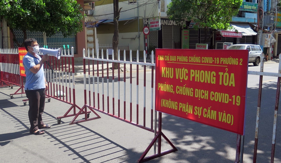 Lực lượng chức năng thông báo cho người trong khu phong tỏa tuân thủ biện pháp phòng dịch COVID-19. (Ảnh: Xuân Triệu/TTXVN)