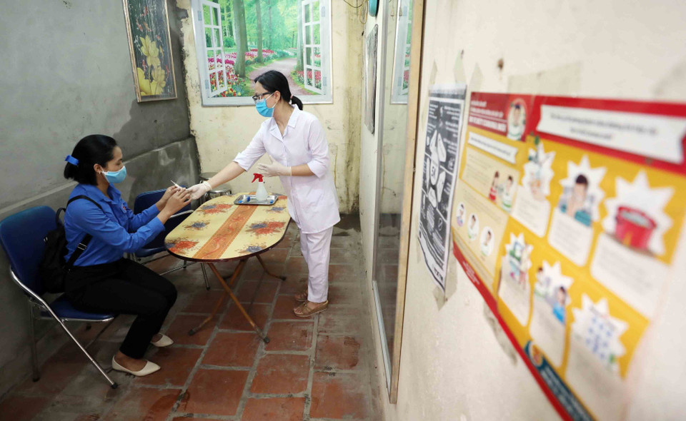 Cán bộ y tế kiểm tra sức khoẻ ban đầu cho thí sinh có biểu hiện ho sốt bất thường để có hướng xử lý tiếp theo. (Ảnh: Thanh Tùng/TTXVN)