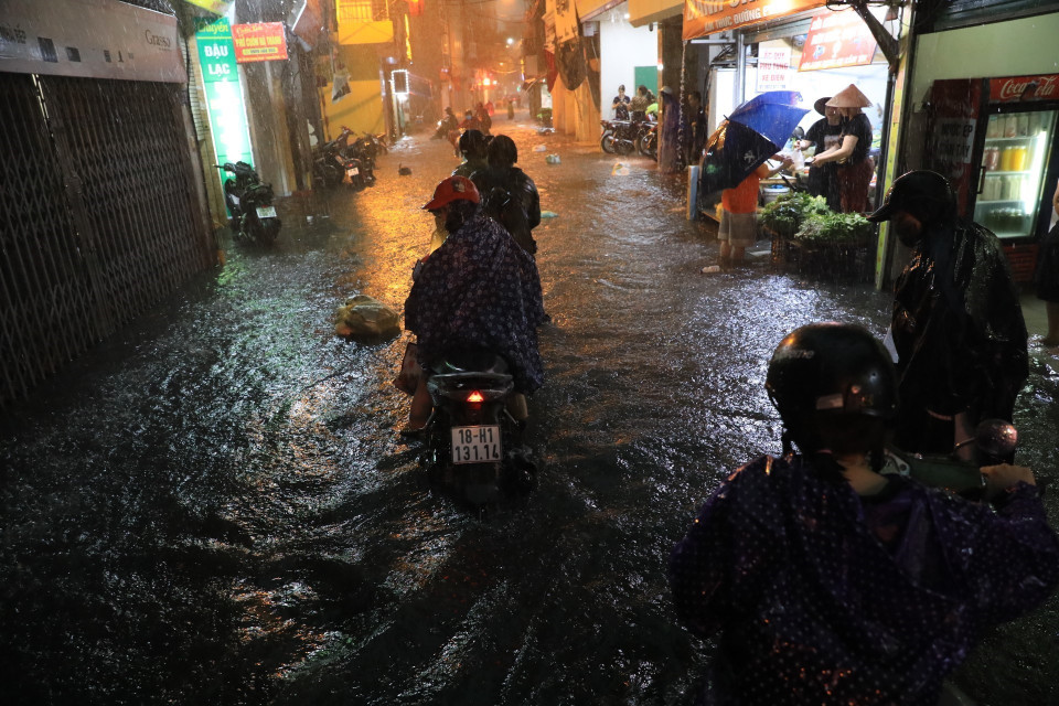 Phố Bùi Xương Trạch ngập nặng ngập khiến nhiều người không đi qua được. (Ảnh: Tuấn Anh/TTXVN)