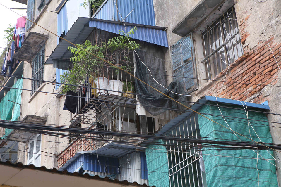 Nhiều hộ đang sinh sống tại tòa nhà chung cư 5 tầng trên đường Trần Đăng Ninh tự ý cơi nới, sửa chữa làm ảnh hưởng đến kết cấu của khu nhà. (Ảnh: Công Luật/TTXVN)
