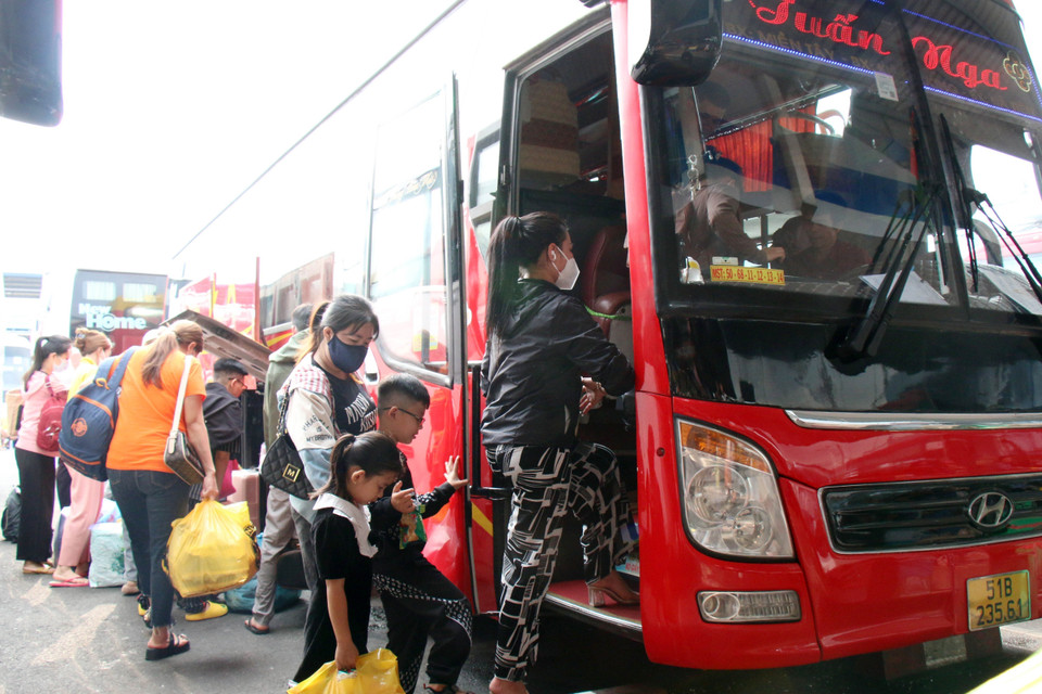 Hành khách lên xe về quê đón Tết Nguyên đán Giáp Thìn 2024. (Ảnh: Tiến Lực/TTXVN)