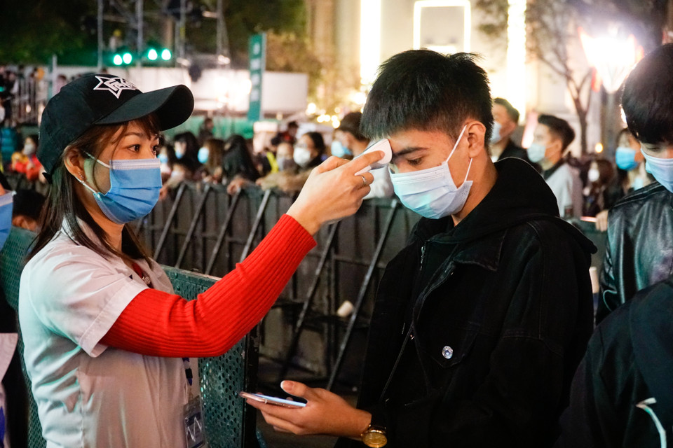 Người dân đang được tiến hành đo thân nhiệt. (Ảnh: Minh Hiếu/Vietnam+)