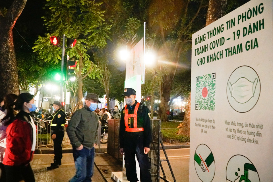 Lực lượng chức năng từ sớm đã có mặt để nhắc nhở người dân đeo khẩu trang, rửa tay khử khuẩn khi tham gia sự kiện. (Ảnh: Minh Hiếu/Vietnam+)