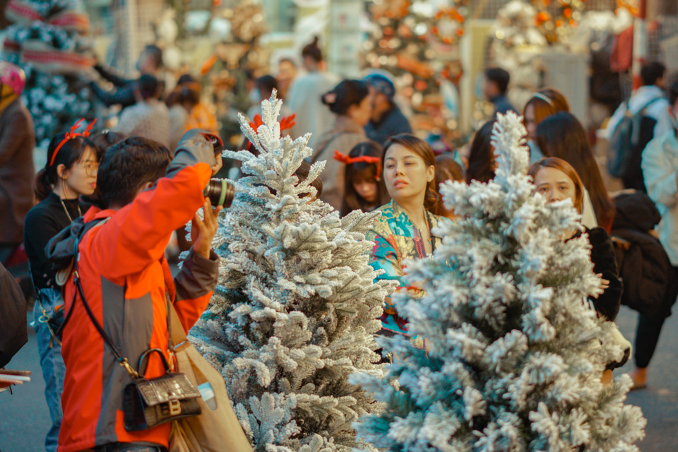 Các cửa hàng đã đông người đến mua sắm hơn so với các ngày thường trong tuần. Một số quán bán trang trí thu phí chụp ảnh đối với khách đến chụp mà không mua sắm từ 20-50 nghìn đồng. (Ảnh: Minh Hiếu/Vietnam+) 