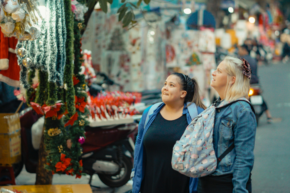 Du khách nước ngoài cũng tranh thủ đi ngắm và tận hưởng không khí Giáng Sinh tại con phố này. (Ảnh: Minh Hiếu/Vietnam+) 