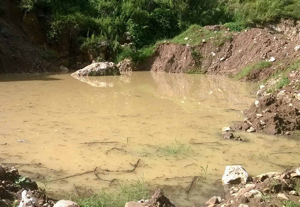 Đất bị múc thành hố nước sâu. (Ảnh: Quang Duy/Vietnam+)