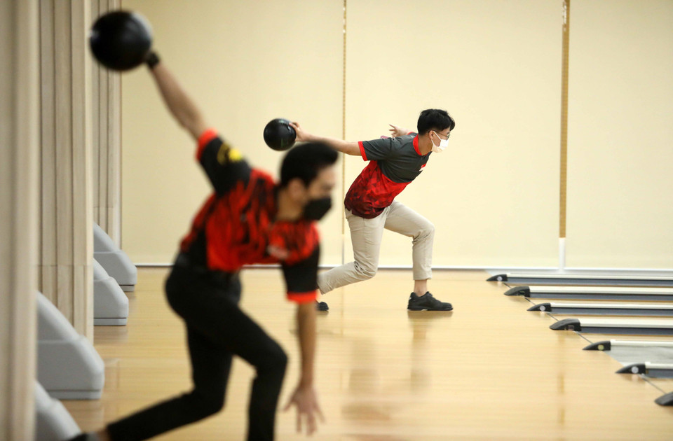 Vận động viên Malaysia (áo đỏ, bên trái) và vận động viên Singapore thực hiện những lần ném đầu tiên. (Ảnh: Trung Kiên/TTXVN)