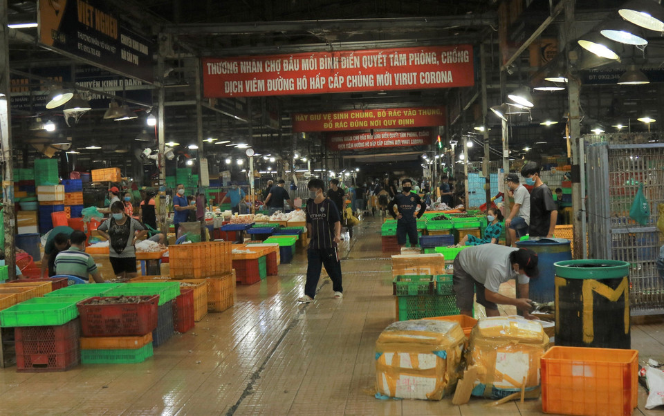 Tiểu thương ở phân loại hải sản ở khu vực buôn bán hải sản ở chợ đầu mối Bình Điền. (Ảnh: Anh Tuấn/TTXVN)