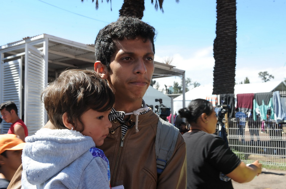 Nét mệt mỏi hiện rõ trên gương mặt hai bố con người Honduras. (Ảnh: Việt Hùng/Vietnam+)